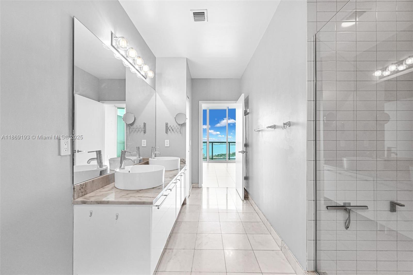 888 Biscayne Boulevard, Unit 5010 Miami, FL 33132 - Photo 8 of 18 a bathroom with a double vanity sink toilet and shower