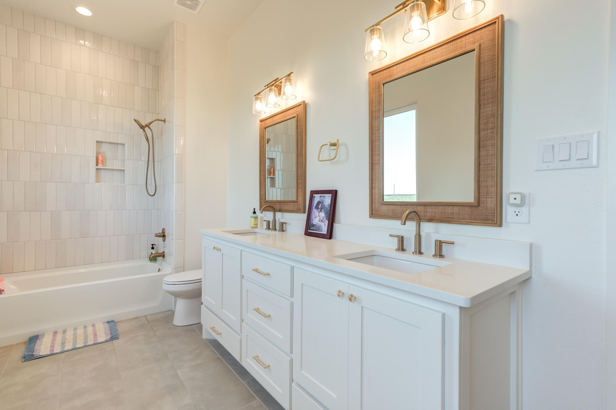 1735 Lovebird Road Lubbock, TX 79407 - Photo 31 of 44 a bathroom with a double vanity sink a toilet and a bathtub