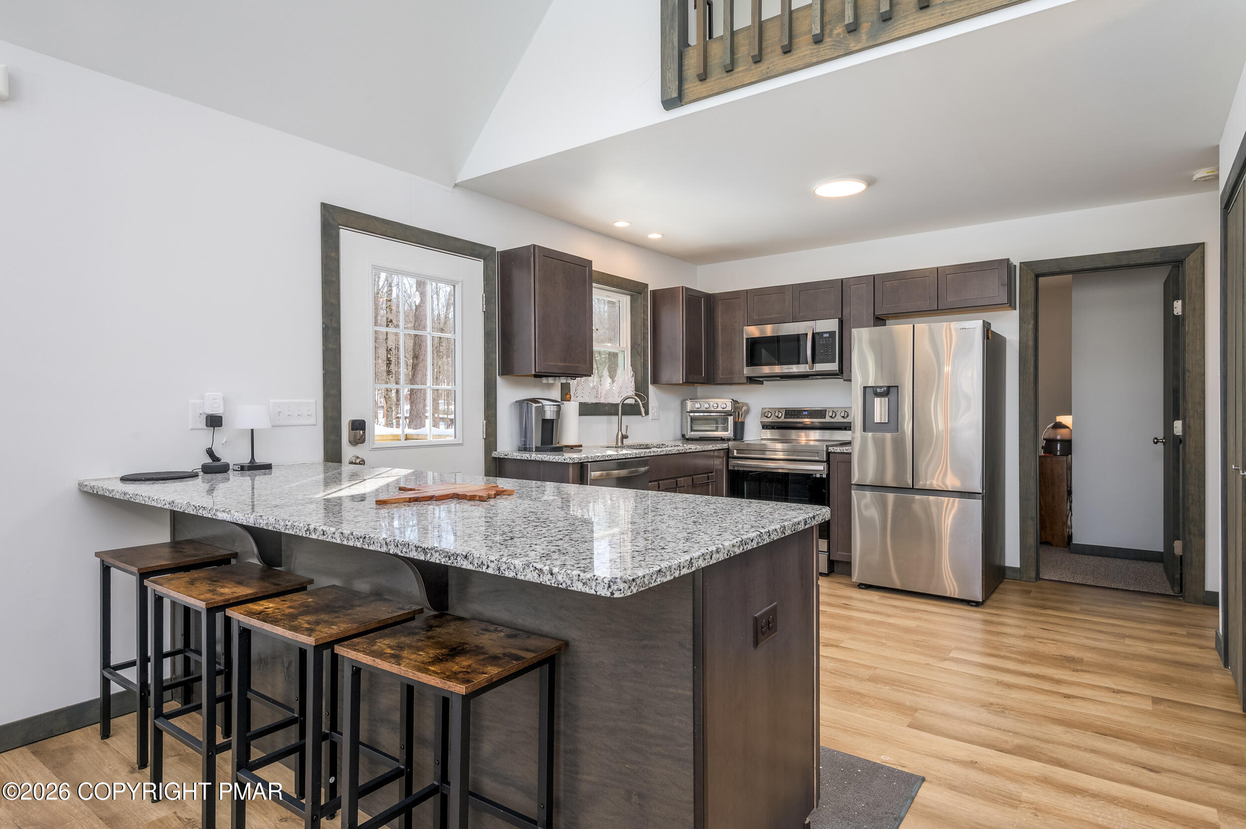 1819 Stag Run Pocono Lake, PA 18347 - Photo 8 of 40 a kitchen with stainless steel appliances granite countertop a table chairs refrigerator and sink