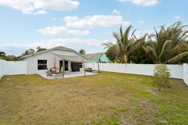 a view of a house with pool and chairs