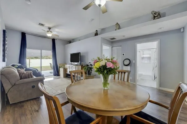 a dining room with furniture potted plants and wooden floor