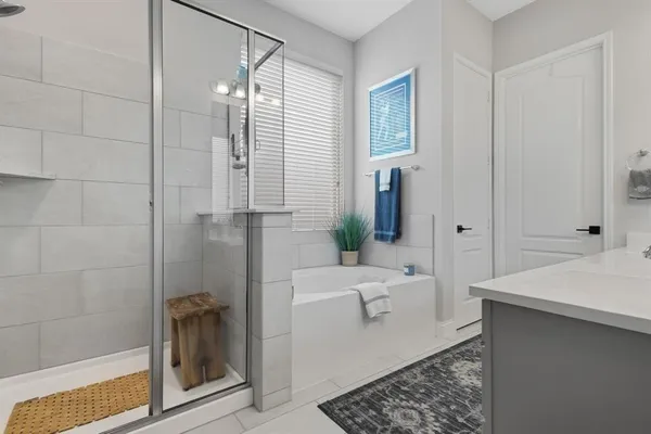 a bathroom with a tub a sink and glass door