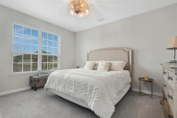 a spacious bedroom with a bed and a window