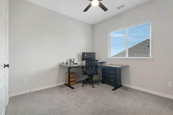 a view of a workspace with furniture and a window