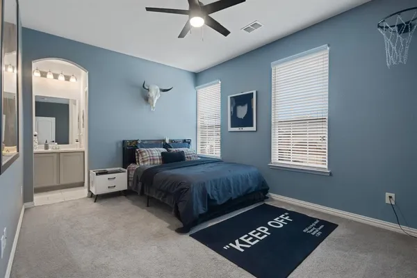 a spacious bedroom with a bed and a chandelier