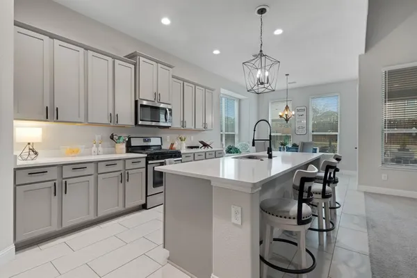 a kitchen with granite countertop a sink stainless steel appliances and cabinets