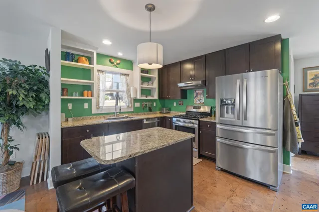 a kitchen with kitchen island a stove and a refrigerator