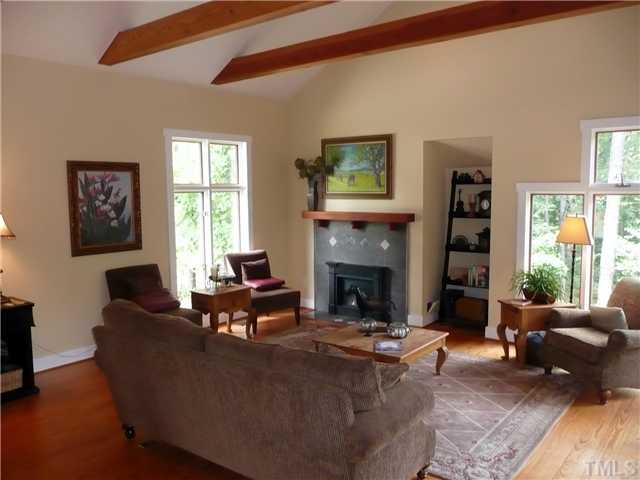 13320 Melvin Arnold Road Raleigh, NC 27613 - Photo 4 of 25 a living room with furniture a large window and a fireplace
