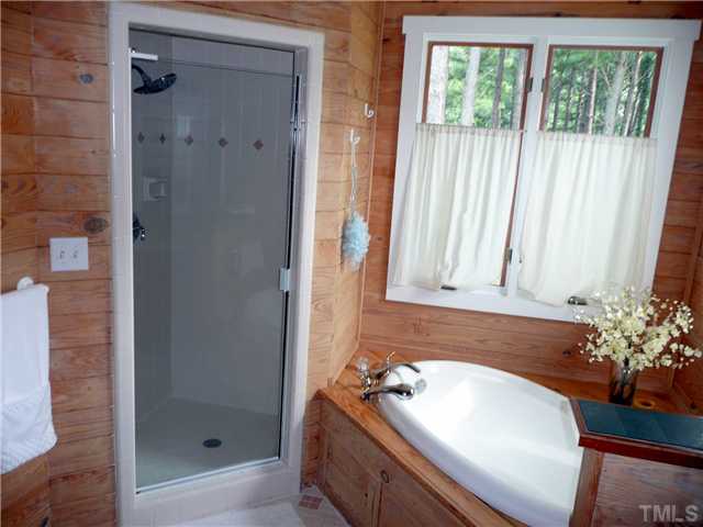 13320 Melvin Arnold Road Raleigh, NC 27613 - Photo 8 of 25 a bathroom with a tub shower and sink