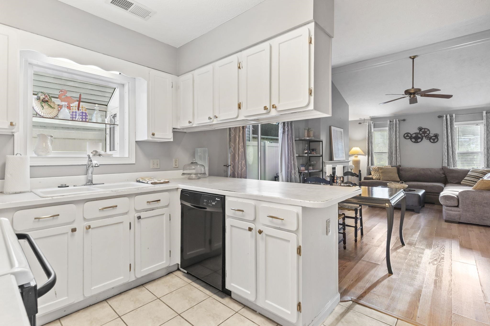 811 9th Avenue South North Myrtle Beach, SC 29582 - Photo 35 of 35 Kitchen with a peninsula, white cabinets, black dishwasher, open floor plan, and light countertops