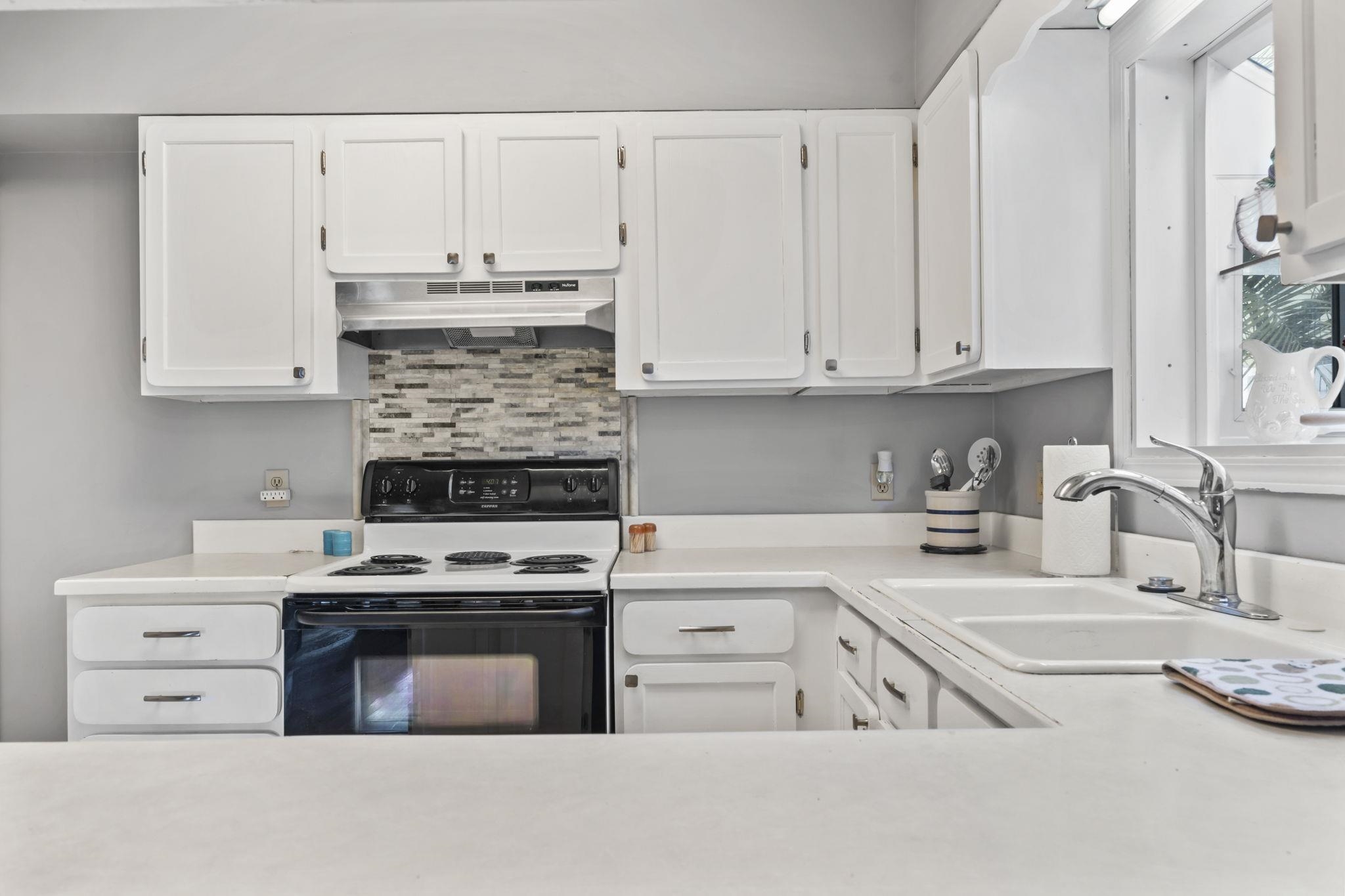 811 9th Avenue South North Myrtle Beach, SC 29582 - Photo 11 of 35 Kitchen with white cabinetry, electric range oven, light countertops, and decorative backsplash