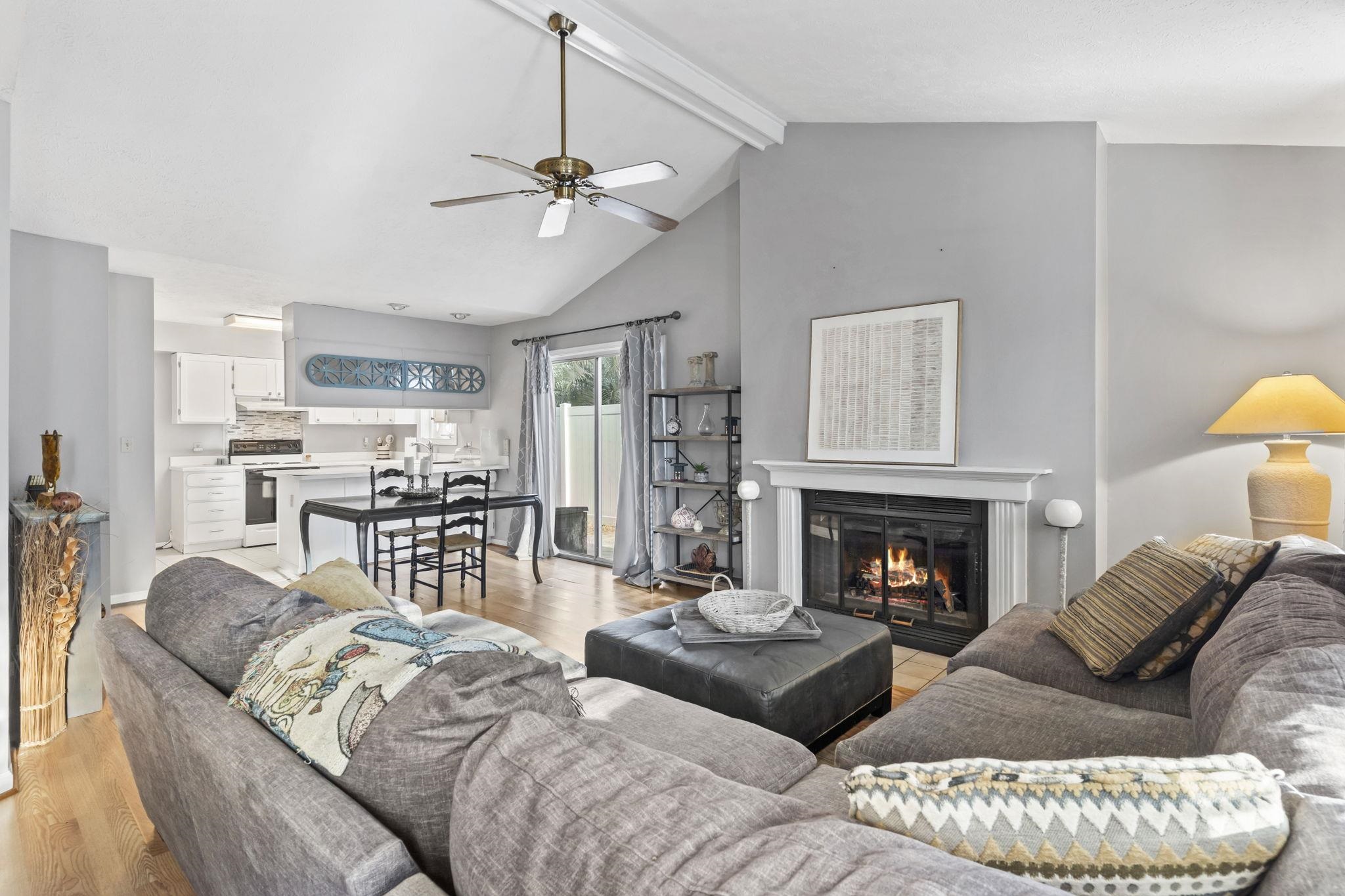 811 9th Avenue South North Myrtle Beach, SC 29582 - Photo 5 of 35 Living area featuring beamed ceiling, light wood-style floors, a glass covered fireplace, ceiling fan, and high vaulted ceiling