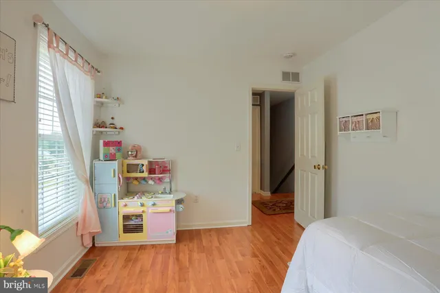 a bedroom with a bed and a wooden floor