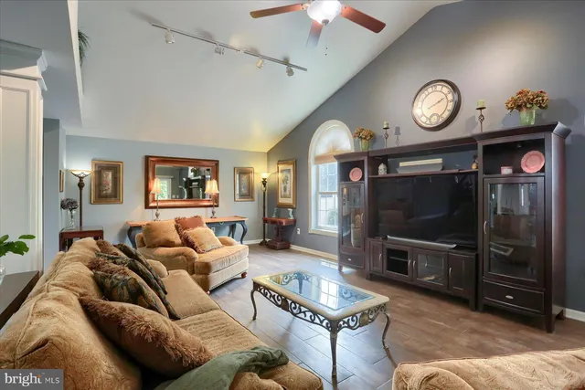 a living room with furniture a flat screen tv and a clock