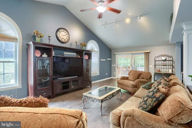 a living room with furniture a flat screen tv and a window