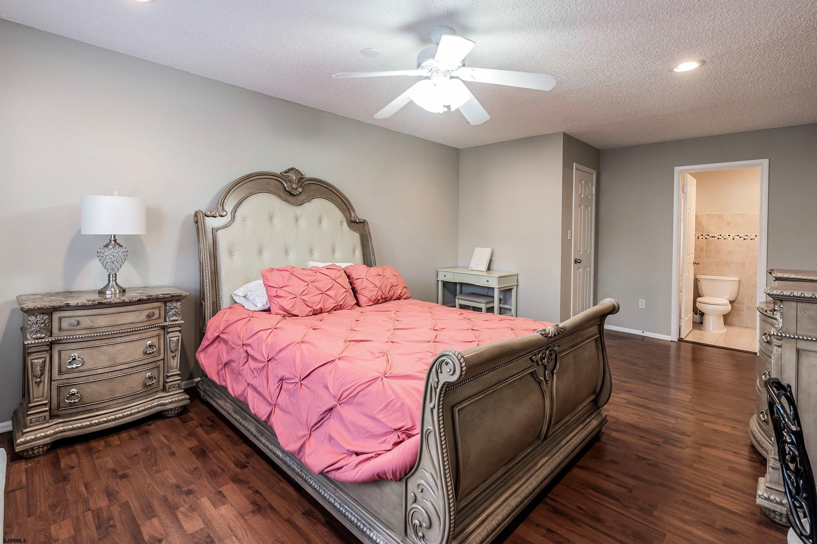209 Daisy Court, Unit 209 Jackson, NJ 08527 - Photo 14 of 26 a bedroom with a bed and a chandelier