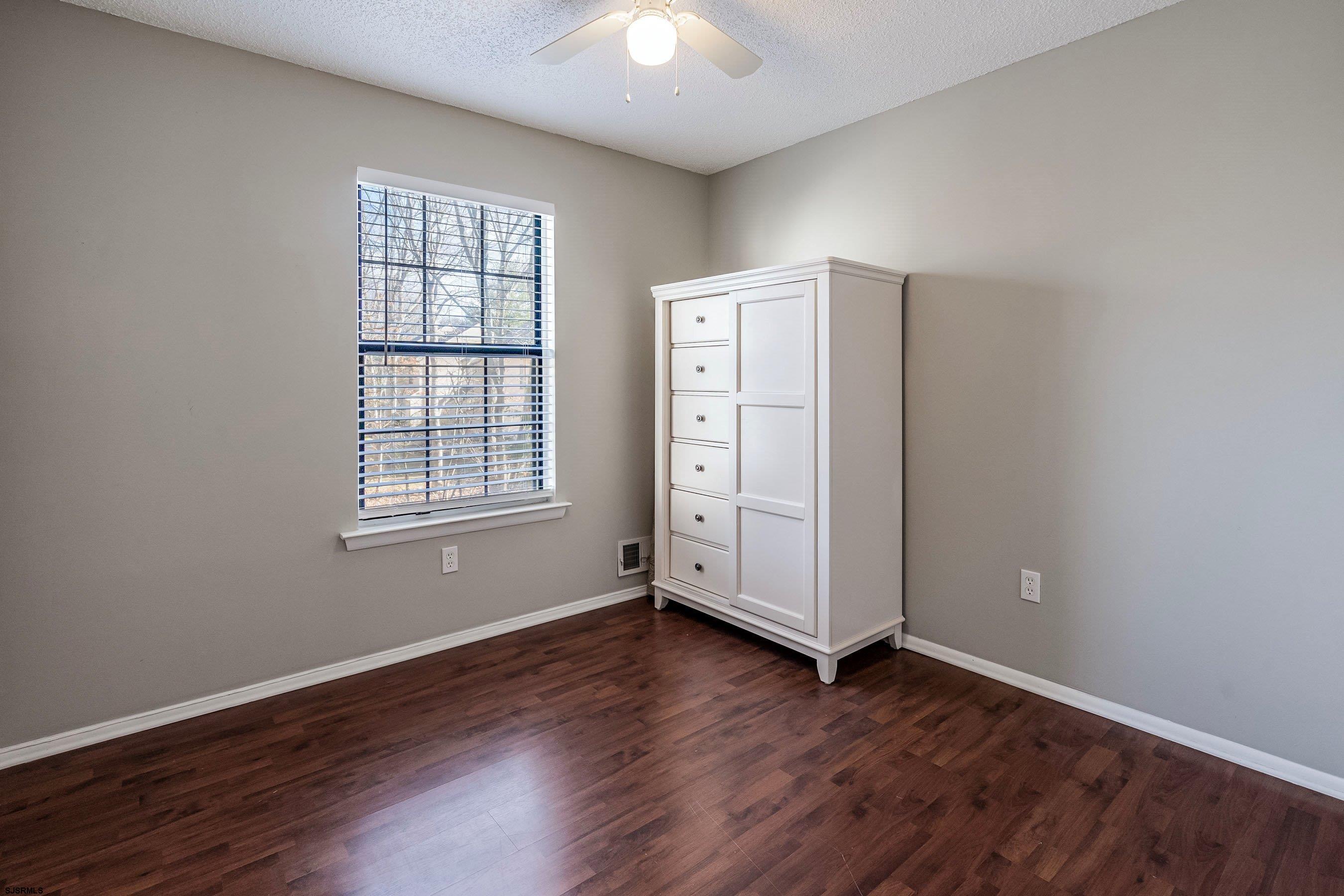 209 Daisy Court, Unit 209 Jackson, NJ 08527 - Photo 16 of 26 an empty room with wooden floor and windows
