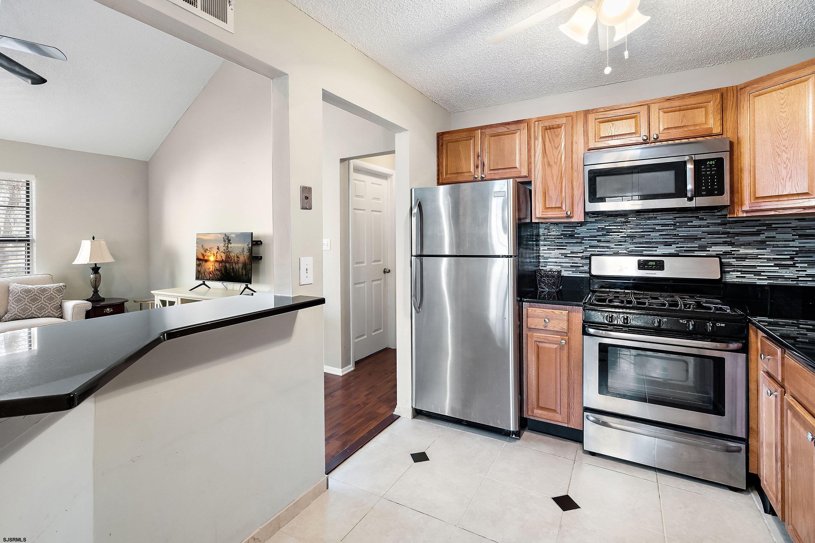 209 Daisy Court, Unit 209 Jackson, NJ 08527 - Photo 4 of 26 a kitchen with stainless steel appliances a refrigerator stove microwave and sink
