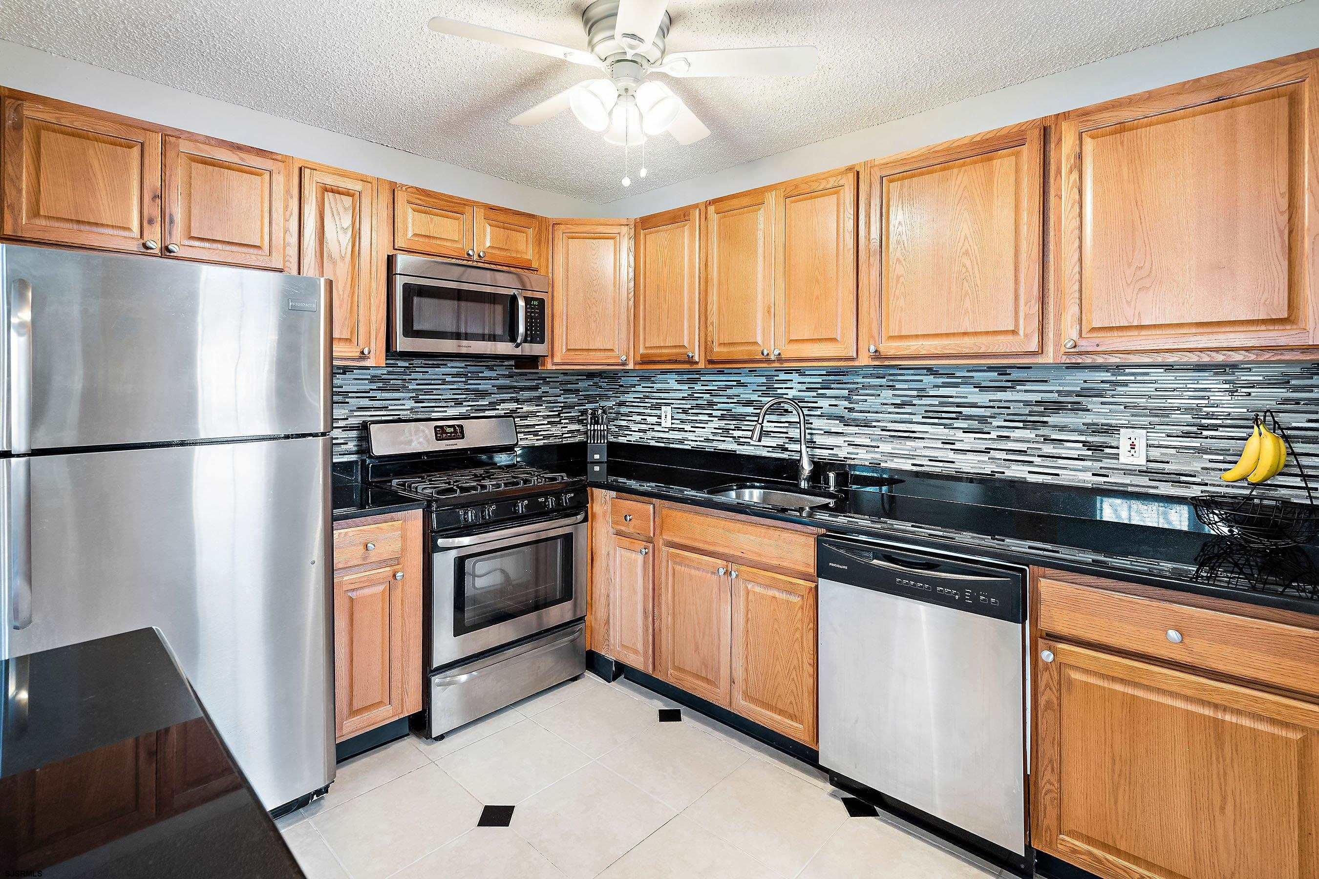 209 Daisy Court, Unit 209 Jackson, NJ 08527 - Photo 5 of 26 a kitchen with granite countertop stainless steel appliances a sink stove and refrigerator