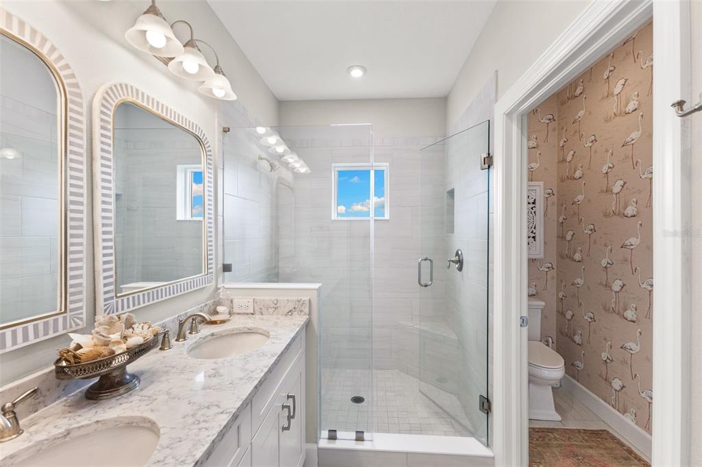 2503 Coral Court Indian Rocks Beach, FL 33785 - Photo 25 of 42 a bathroom with a granite countertop double vanity sink mirror and shower