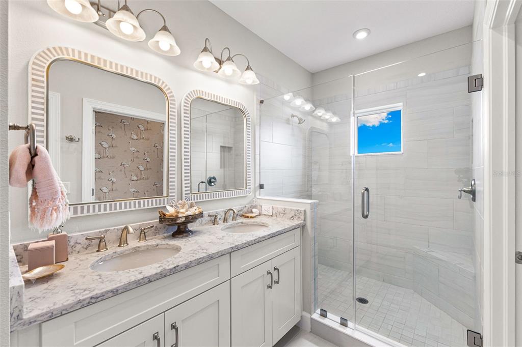 2503 Coral Court Indian Rocks Beach, FL 33785 - Photo 26 of 42 a bathroom with a granite countertop sink mirror and shower