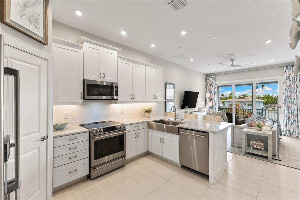 2503 Coral Court Indian Rocks Beach, FL 33785 - Photo 8 of 42 a kitchen with stainless steel appliances kitchen island granite countertop a sink and cabinets