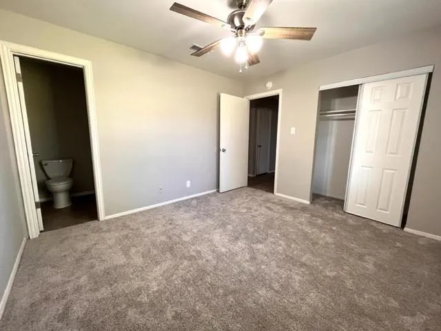 a view of a big room with closet and a ceiling fan