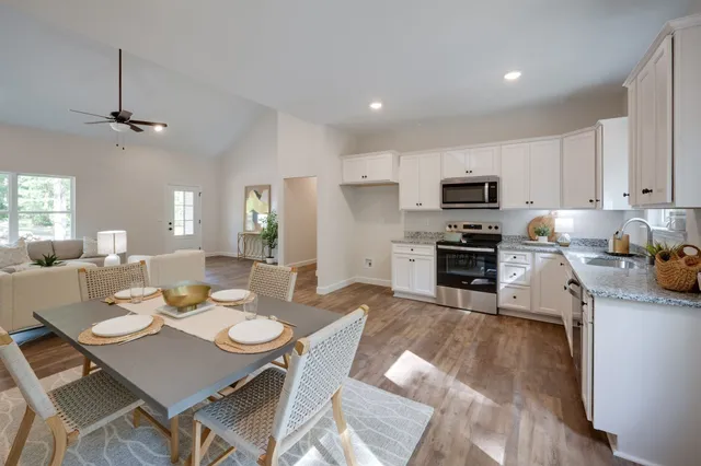 a view of a dining room with furniture a kitchen and chandelier