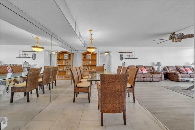 a dining hall with couches a flat tv screen and a dining table with garden view