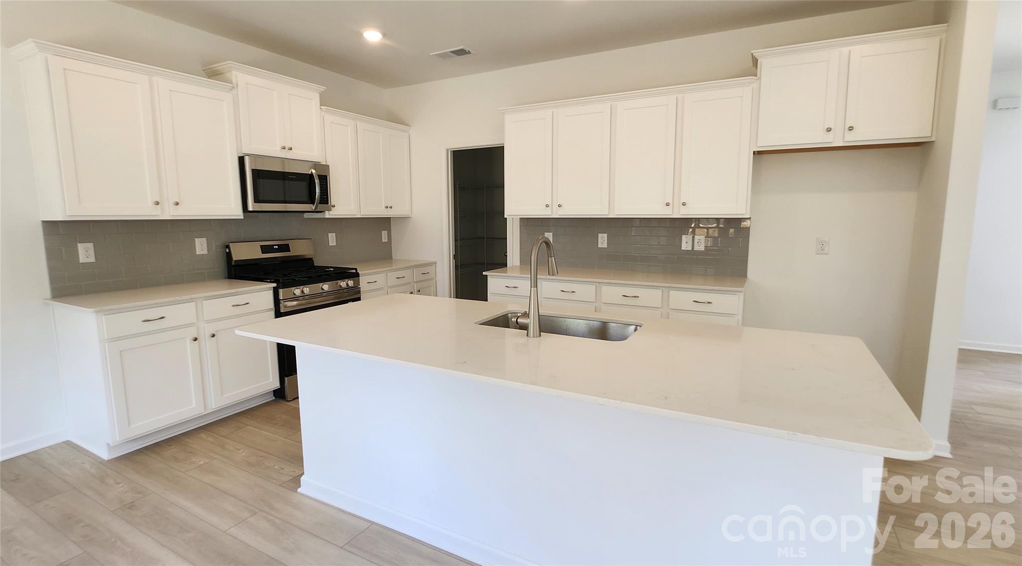 7014 Juneberry Way Maiden, NC 28650 - Photo 2 of 31 a kitchen with stainless steel appliances a sink a stove a microwave and cabinets