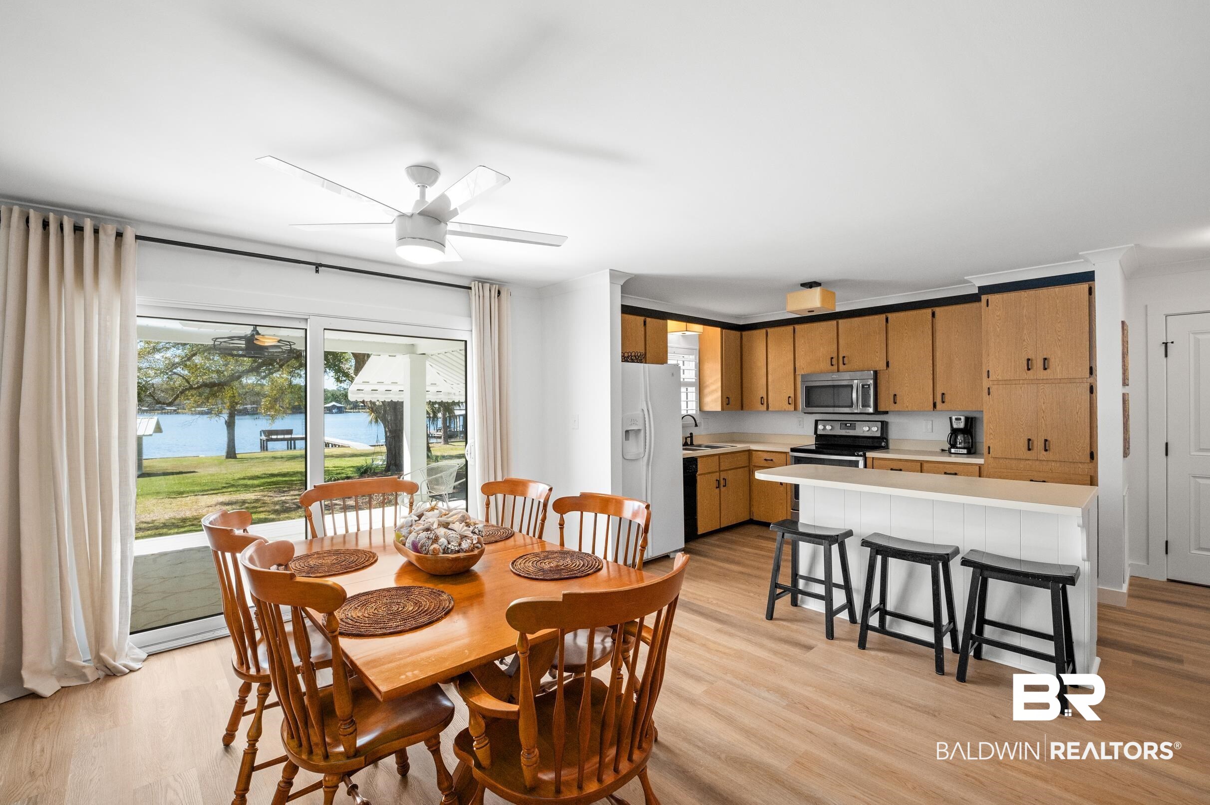 9459 Soldier Creek Road Lillian, AL 36549 - Photo 6 of 54 Dining room featuring a water view, light wood finished floors, and a ceiling fan
