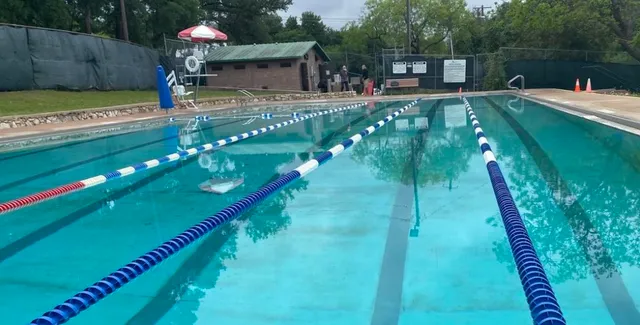 a view of a lake with tall buildings next to a road