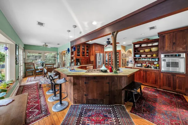 a living room with furniture a rug and kitchen view