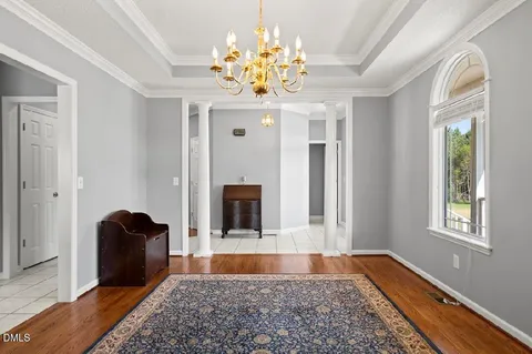 a living room with a fireplace and chandelier