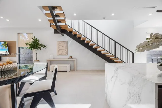 a view of a dining room with floor to ceiling window and potted plants