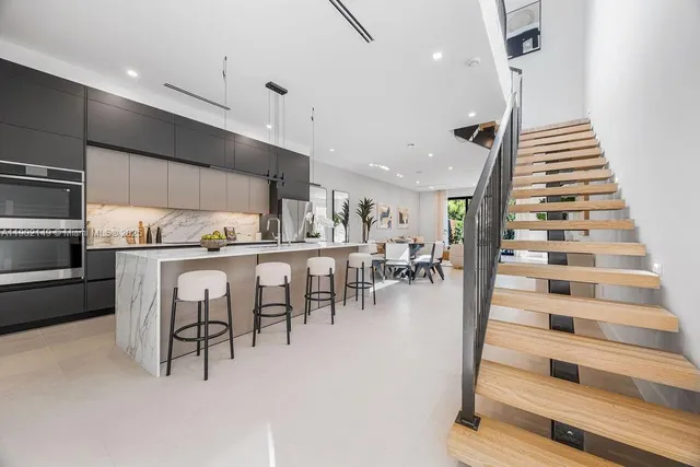 a dining room with kitchen island furniture a chandelier and kitchen view