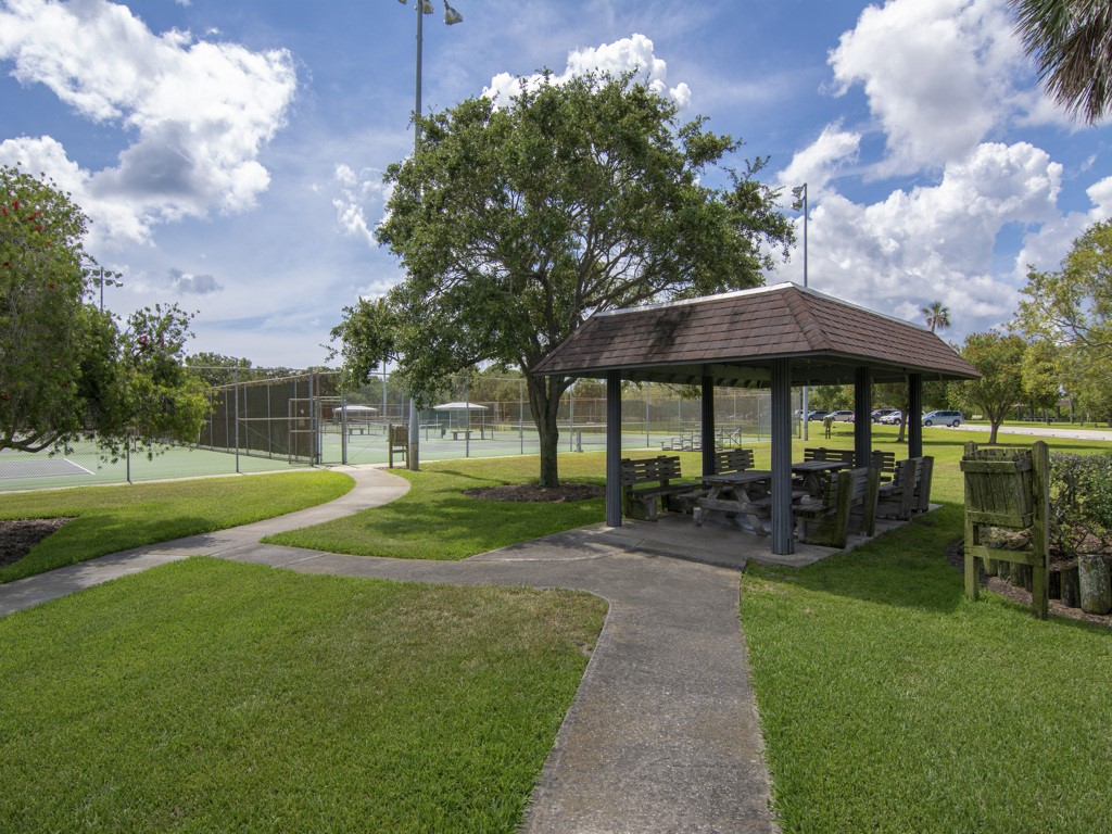 275 Date Palm Road, Unit 304 Vero Beach, FL 32963 - Photo 23 of 36 a view of a table and chairs under an umbrella