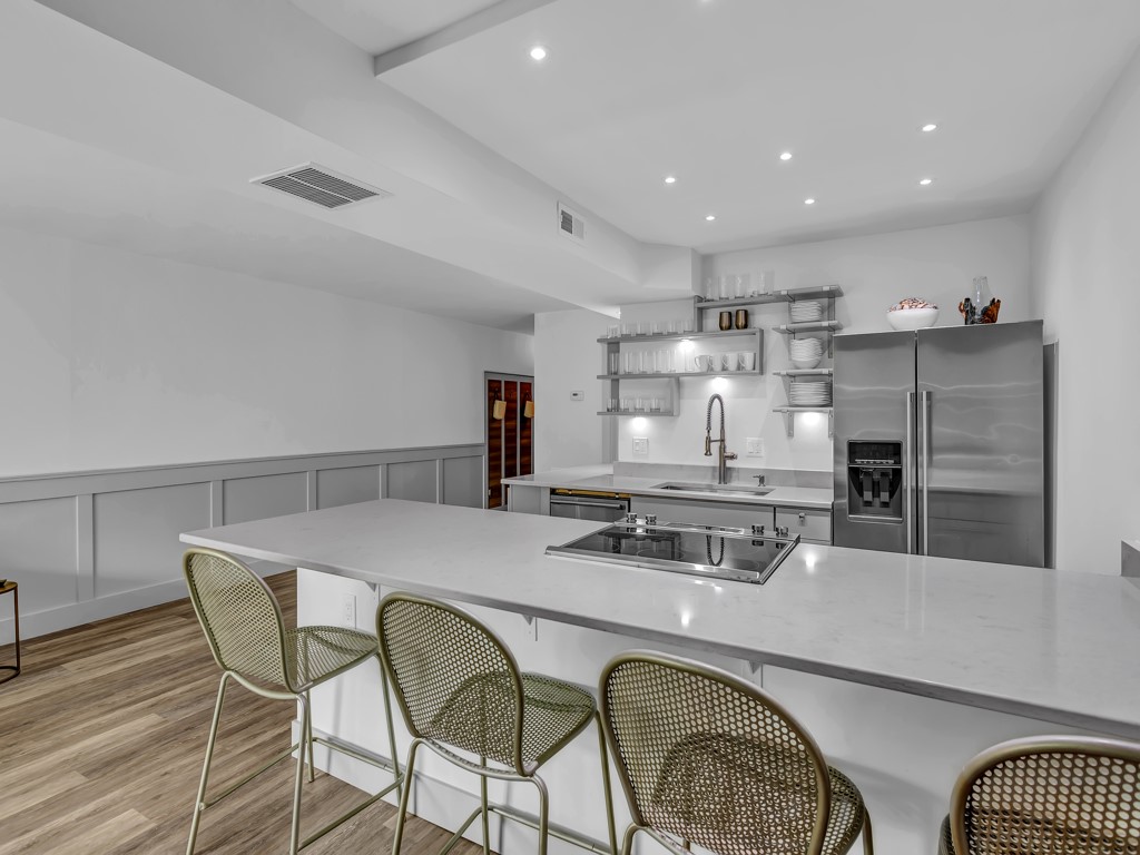 275 Date Palm Road, Unit 304 Vero Beach, FL 32963 - Photo 7 of 36 a kitchen with stainless steel appliances granite countertop a stove a dining table and chairs with wooden floor