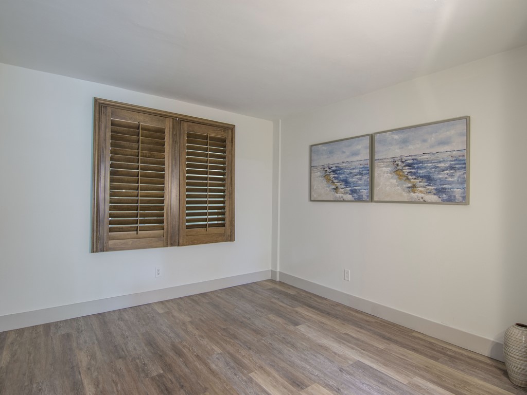 275 Date Palm Road, Unit 304 Vero Beach, FL 32963 - Photo 10 of 36 a view of an empty room with a window and wooden floor