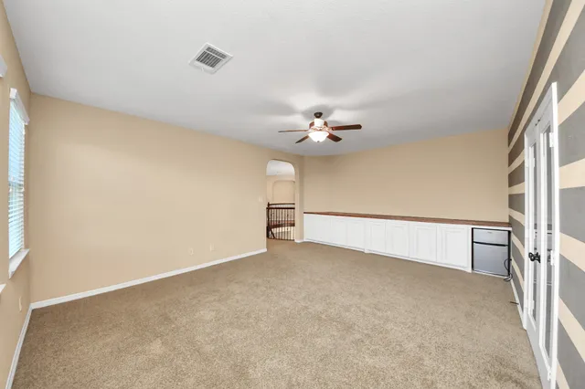 a view of an empty room with a chandelier fan
