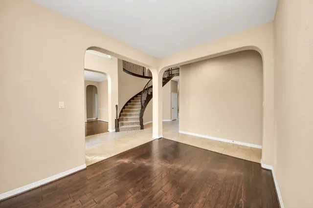 a view of a room with wooden floor chandelier and a window