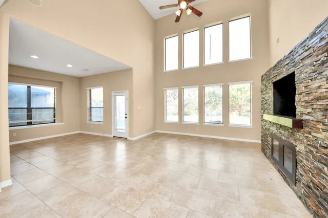 an empty room with windows and fan