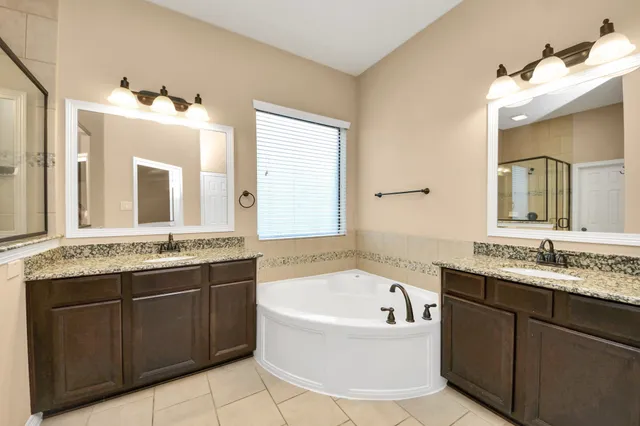 a bathroom with a granite countertop sink and a bathtub