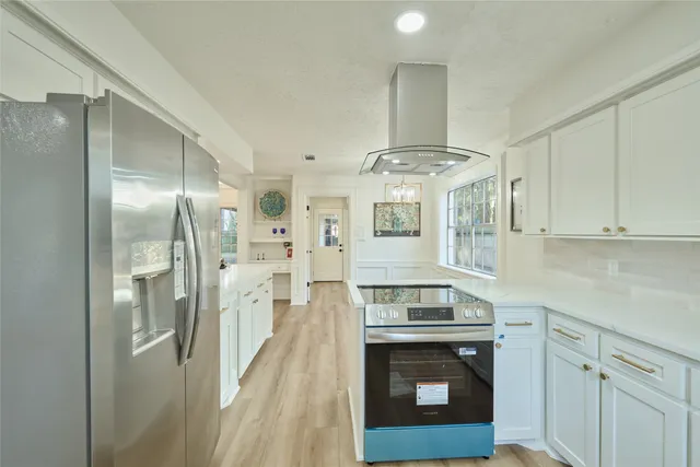 a kitchen with stainless steel appliances granite countertop a stove and a refrigerator
