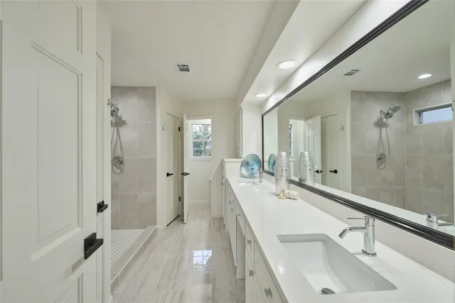 a bathroom with a double vanity sink a mirror and a shower