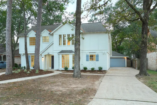 a front view of a house with yard and trees