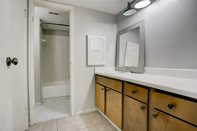 a bathroom with a shower sink and mirror