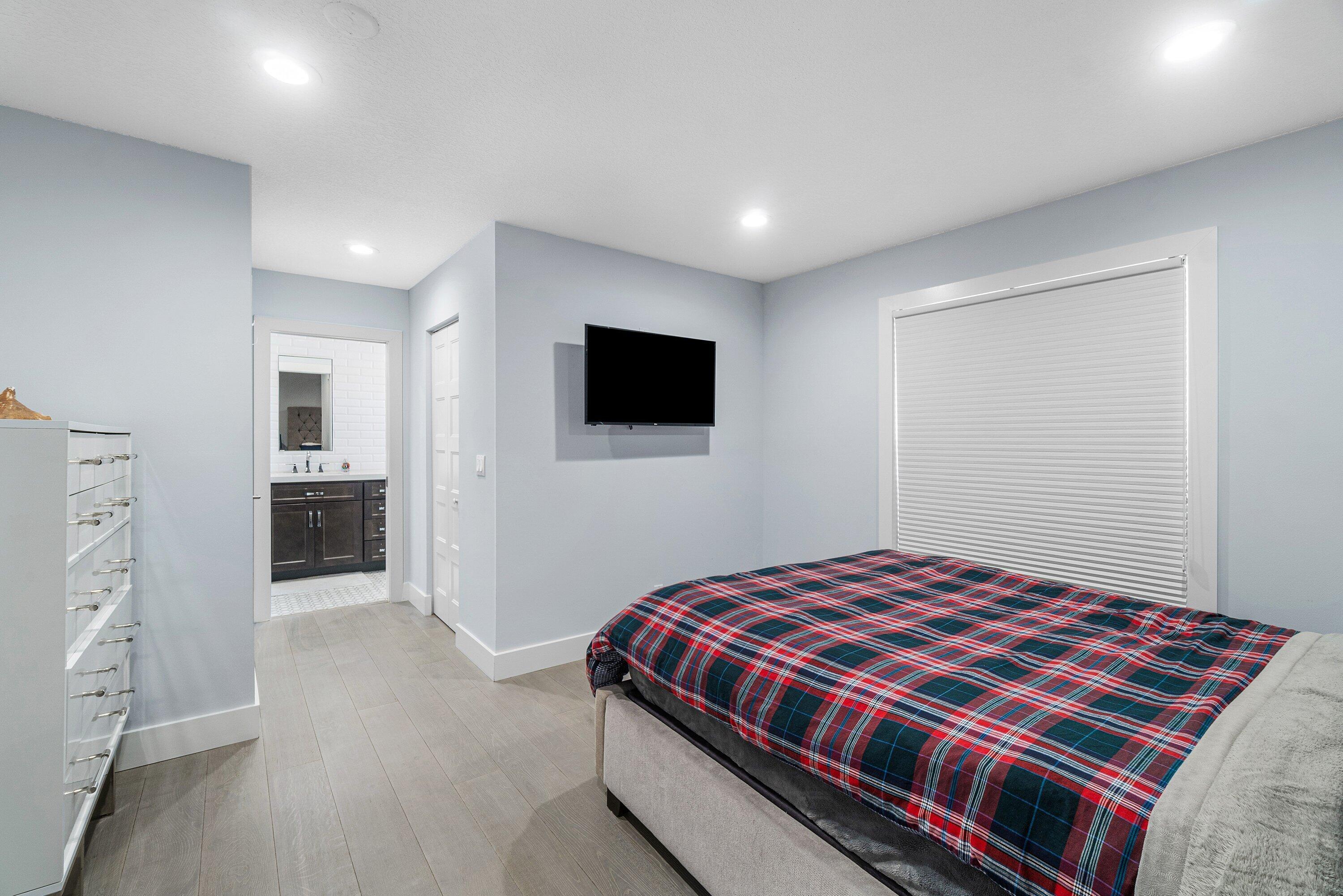 2404 Northwest 67th Street Boca Raton, FL 33496 - Photo 32 of 74 a bedroom with a bed and a flat screen tv