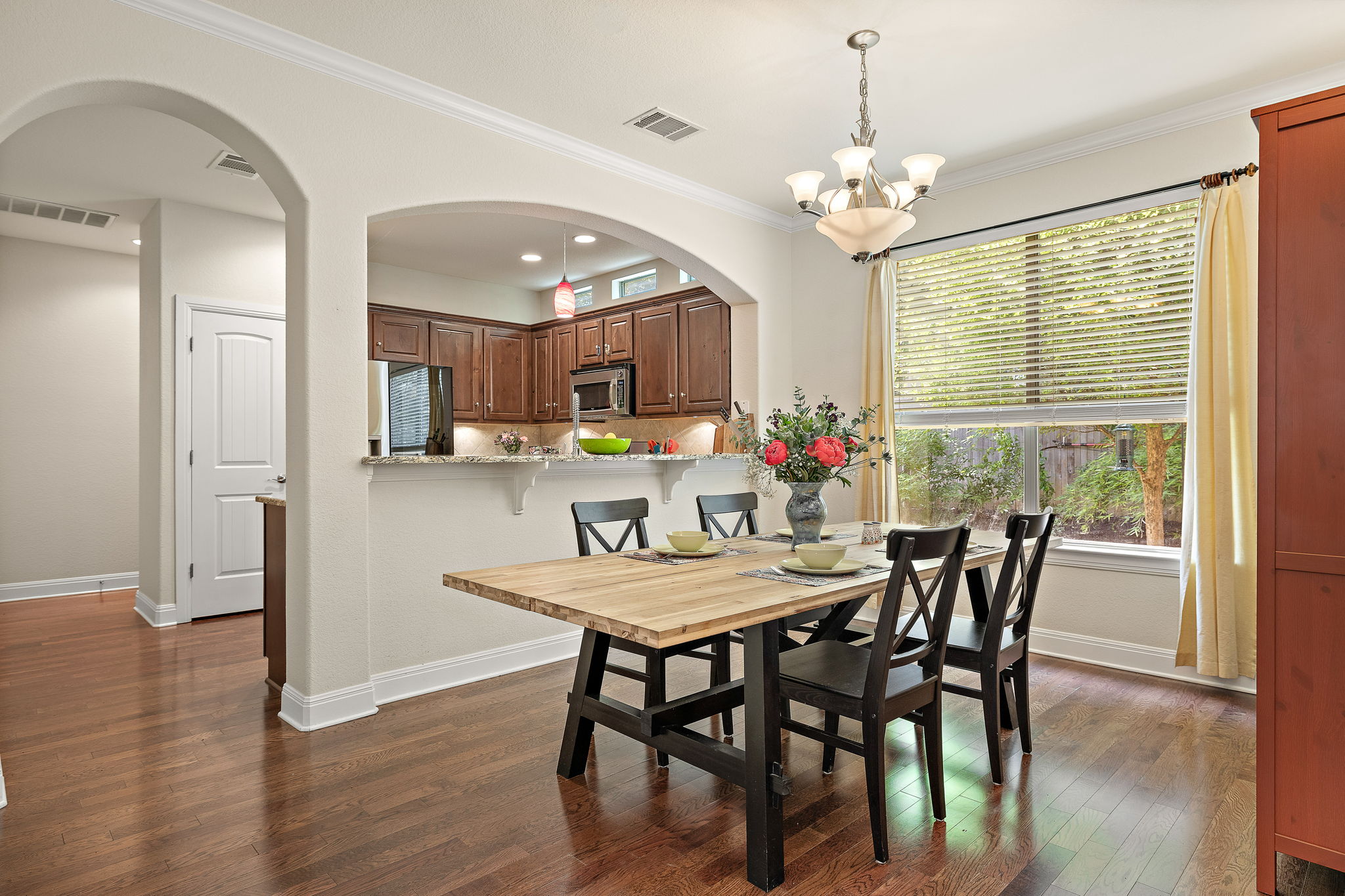 6708 Menchaca Road, Unit 10 Austin, TX 78745 - Photo 11 of 28 Dining area with wood-finish flooring, a contemporary chandelier, and a large window