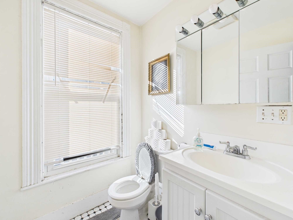 16-22 Reedsdale Street Boston, MA 02134 - Photo 16 of 39 a bathroom with a sink a toilet and a mirror
